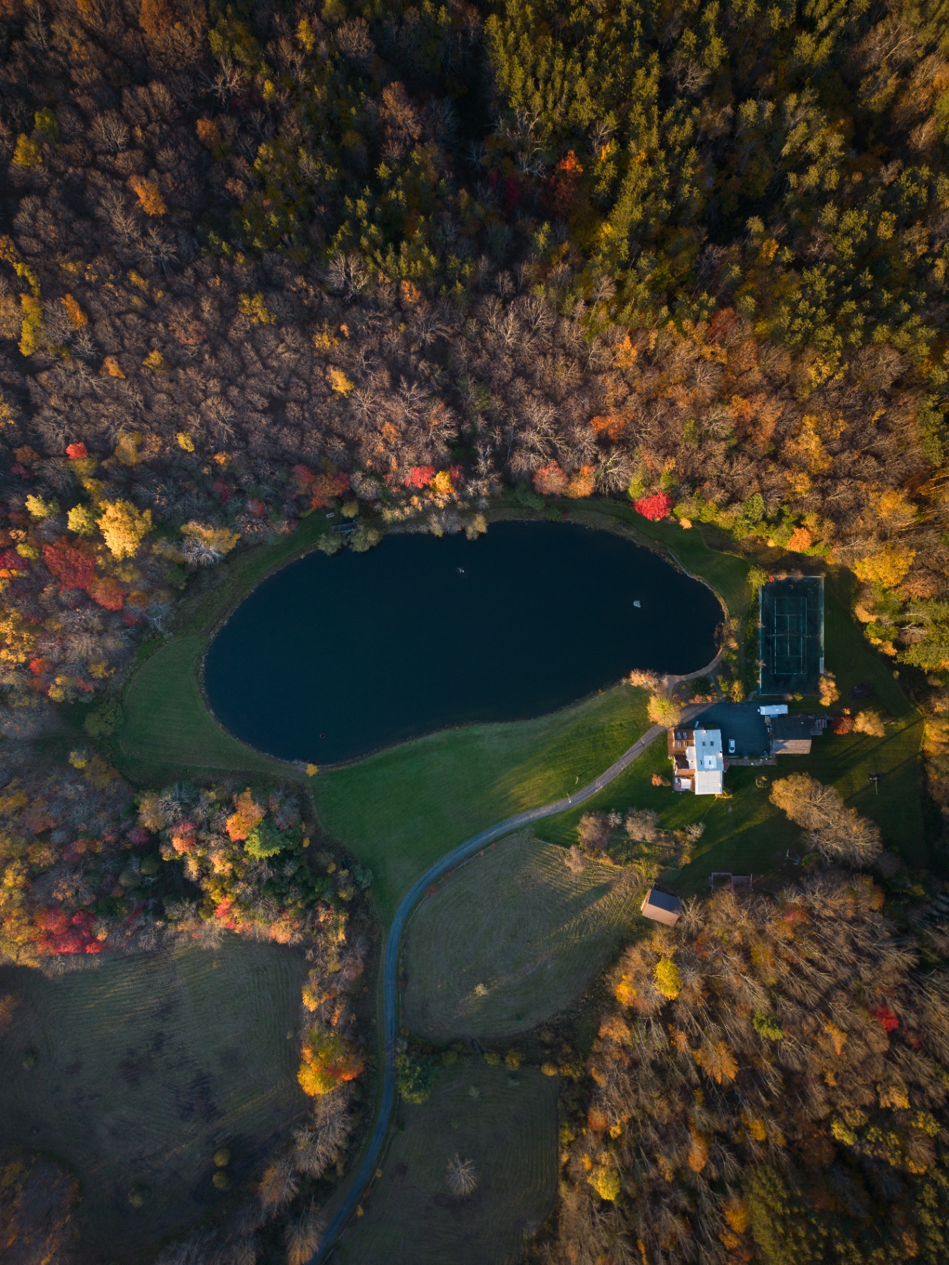 Aerial view of the Apogeeometrix campground pond, meadows and autumn forest